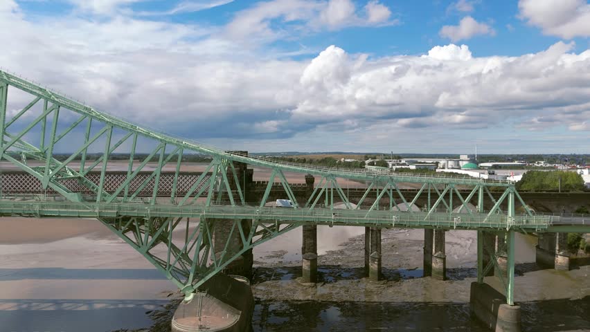 Liverpool, Merseyside, UK, September 09, 2025; aerial 4K video footage of the Silver Jubilee Bridge and Britannia Railway Viaduct over the River Mersey and Manchester Ship Canal, Runcorn, Merseyside