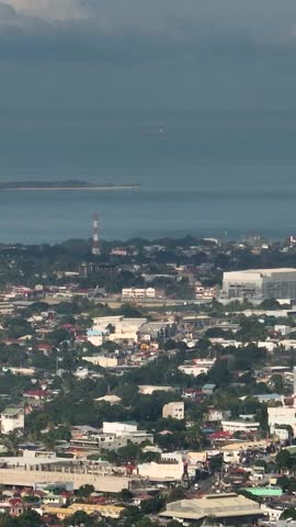 Coastline with modern buildings and towers. Zamboanga City, Philippines. Vertical, stories.