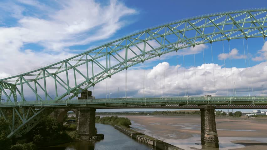Liverpool, Merseyside, UK, September 09, 2025; aerial 4K video footage of the Silver Jubilee Bridge and Britannia Railway Viaduct over the River Mersey and Manchester Ship Canal, Runcorn, Merseyside