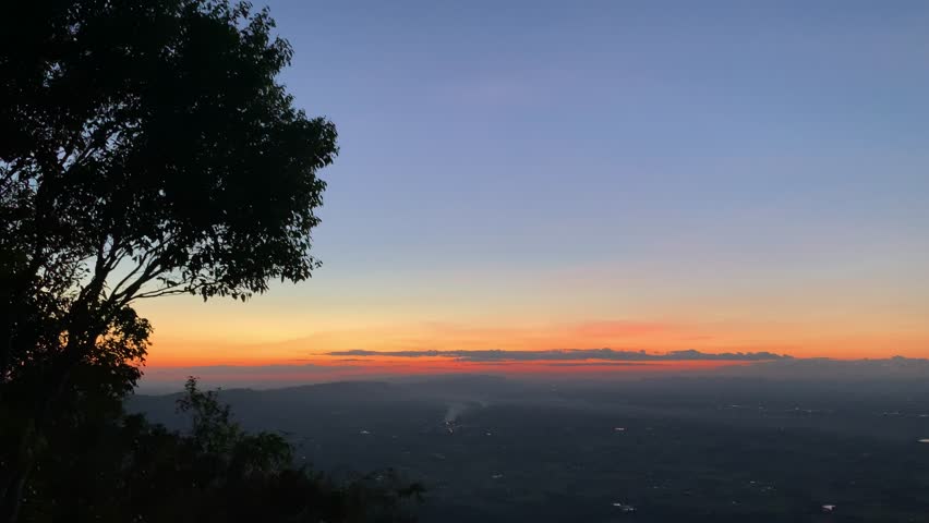 The moment of sunset over a mountaintop in an Asian country.