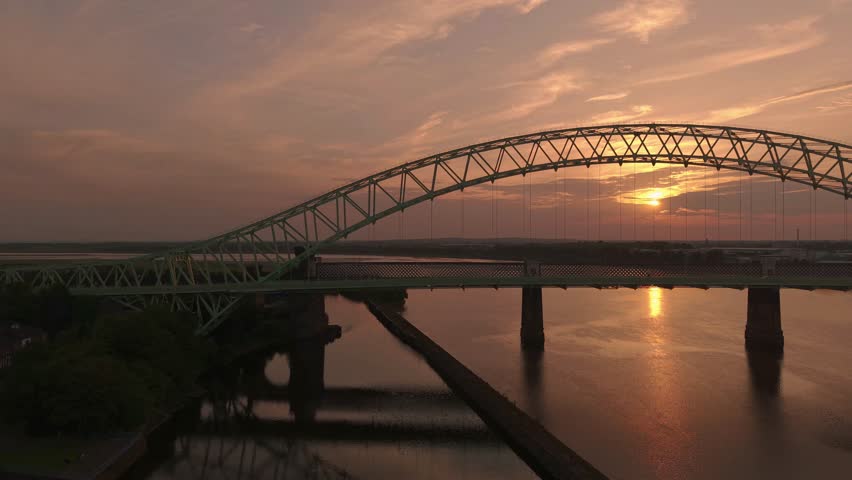Liverpool, Merseyside, UK, September 09, 2025; aerial 4K video footage of the Silver Jubilee Bridge and Britannia Railway Viaduct over the River Mersey and Manchester Ship Canal, Runcorn, Merseyside