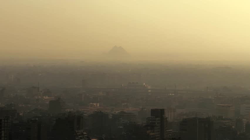 Aerial View of Giza at Sunset with Pyramid Silhouettes Visible on the Horizon