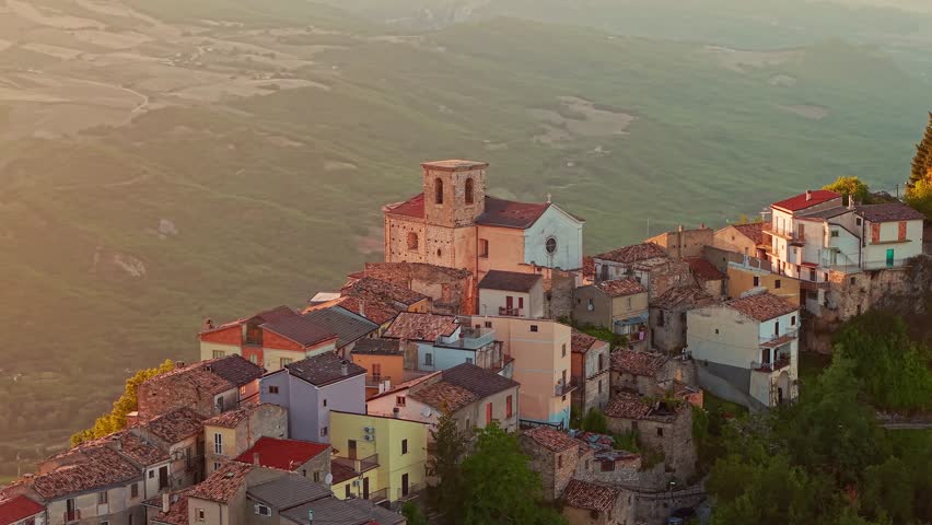 Dramatic aerial view of Monteferrante, a natural balcony of Abruzzo, during a golden sunset. Featuring the medieval ruins of Di Sangro Castle and panoramic views of the Sangro Valley and Lake Bomba.