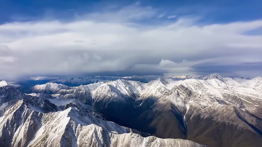This video captures an aerial perspective of a snow-capped mountain range, identified as the Southern Alps or the Pamir Mountains. The visual documents high-altitude peaks, deep valleys, and extensive glacial formations. The composition illustrates alpine geography and geomorphology, documenting terrestrial landforms in a high-resolution 4K format for environmental and editorial media.