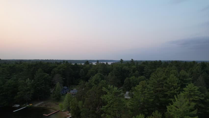 Aerial view of Eagle River Wisconsin in the Northwoods during summer.  Slow rising shot of lake country.
