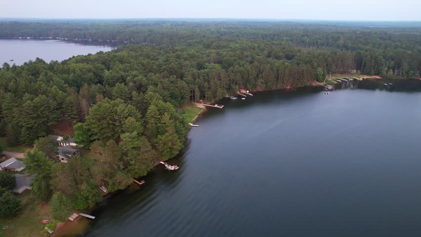Aerial view of Eagle River Wisconsin in the Northwoods during summer.  Slow approach drone shot over lakes.