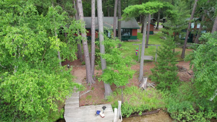 Aerial view of Eagle River Wisconsin in the Northwoods during summer.  Rising drone shot of cabin and tree line over lakes.