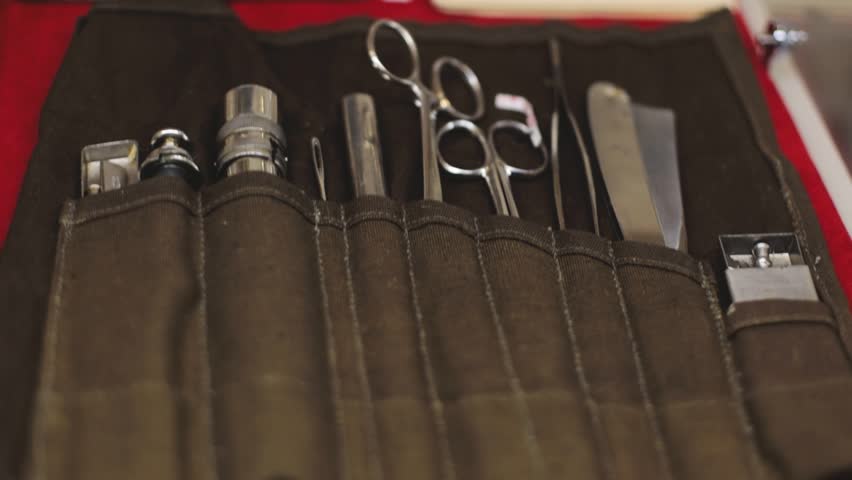 A container filled with various office supplies such as scissors, pens, and paper clips.