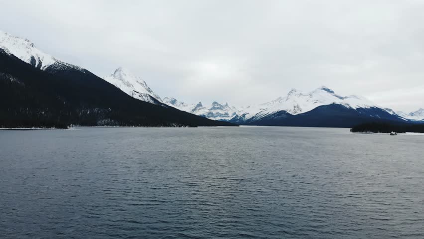 Aerial drone view of partially frozen mountain lake in winter, Jasper National Park Alberta Canada