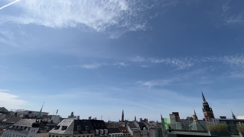 Rooftop view of Copenhagen skyline on a sunny day with blue sky and lots of tourists