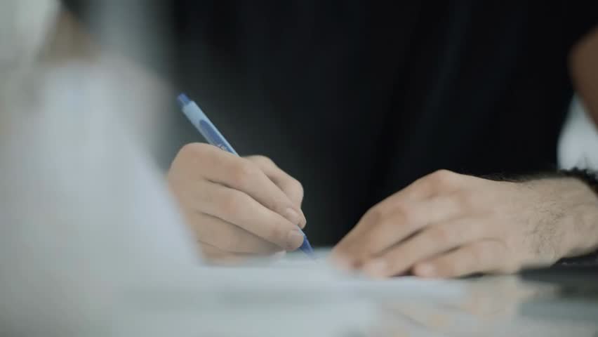 Close-up of hands writing with a pen in a notebook, diary, or notepad, capturing students, journalists, or business professionals taking notes.