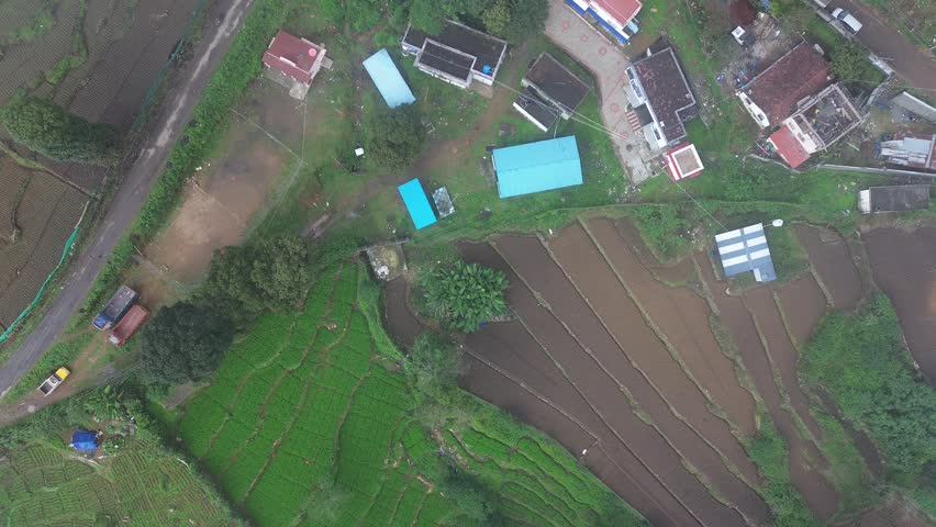 Beautiful mountain scenery showing traditional step farming patterns across the hillside while a road passes through the valley connecting villages and the city.