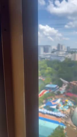 “From the comfort of your elegantly appointed room, step onto the balcony or gaze through floor-to-ceiling windows to behold an exhilarating panorama that blends urban excitement with tropical oasis vibes. Directly below lies the iconic Sunway Lagoon – Malaysia’s premier theme park – where the world’s largest surf pool sparkles under the sun, sending gentle waves crashing in rhythmic symphony. Colorful slides twist like vibrant serpents through lush greenery, while joyful splashes and laughter drift upward on the warm breeze.
In the foreground, swaying palm trees and manicured tropical gardens frame the scene, creating a private resort-like sanctuary amid the adventure. Beyond the lagoon, the skyline of Sunway City rises subtly, with glimpses of modern architecture and the distant hum of city life, yet the view feels worlds away – a perfect fusion of thrill and tranquility.
As day turns to golden hour, the water glows in hues of turquoise and emerald, reflecting the fiery sunset skies. At night, the park lights up in a dazzling display of colorful illuminations, transforming the lagoon into a magical, glowing wonderland right at your feet. Wake up to the promise of endless fun just steps away, or simply relax with this breathtaking, ever-changing spectacle – your personal front-row seat to paradise and play.”