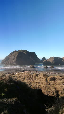Coastal cliff overlooking sea stacks and waves along the Oregon Coast, capturing a wide Pacific Ocean view with rugged shoreline, open sky, and calm natural atmosphere