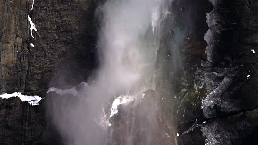 Yosemite Fall in slow motion, Turbulent mist forming subtle rainbow against granite wall, closeup spray and vapor, dispersed light creating iridescent highlights, powerful surge with abstract color 