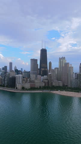 Vertical aerial view of Chicago downtown skyline along Lake Michigan shoreline, modern city architecture, waterfront park and urban beach, scenic summer cityscape