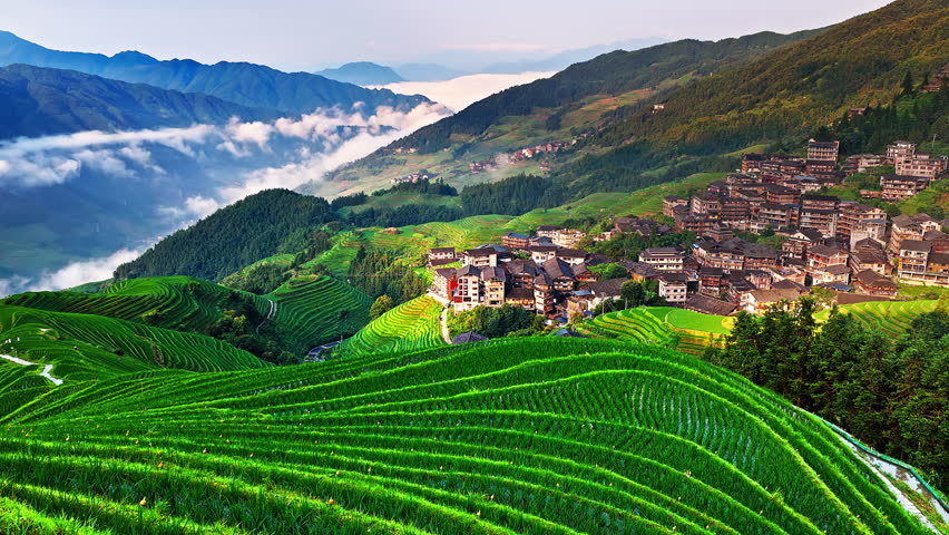 Aerial view of the spectacular Longji Rice Terraces and ethnic village landscape at sunrise in Guilin, China.