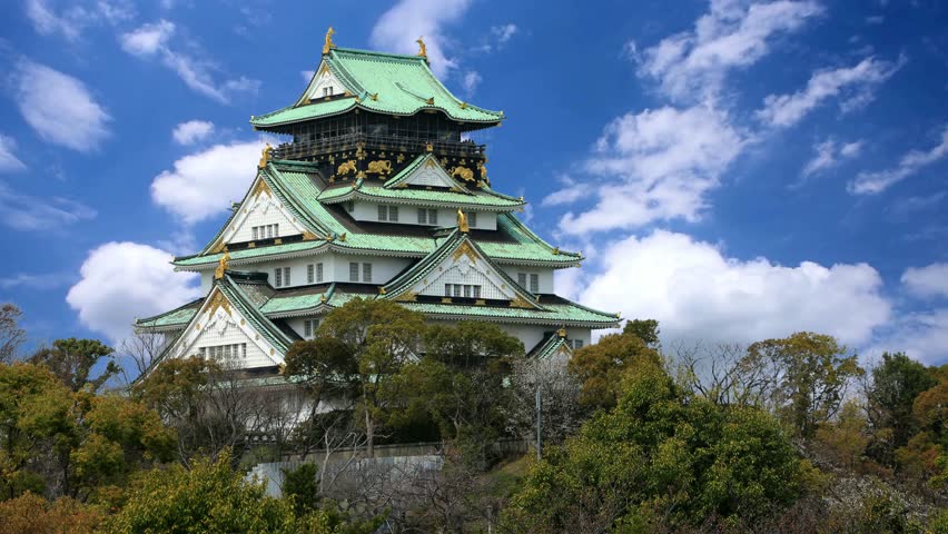 Nagoya Castle A view of the main keep (Tenshu) and surrounding structures of Nagoya Castle, a historic landmark in Japan, with visitors walking on the grounds.Nagoya Castle and city skyline in Japan with blue skyHimeji, Japan castle time lapse.