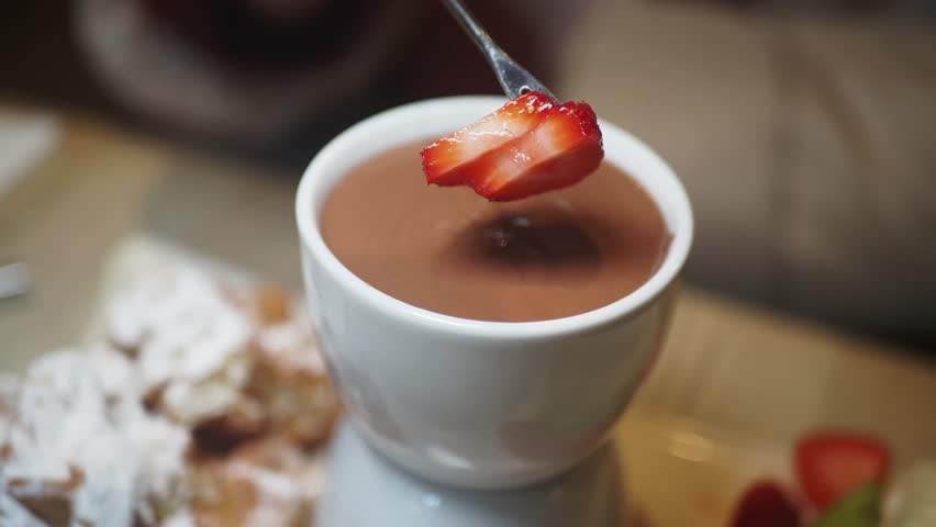 Indulging in rich chocolate dip with fresh strawberries