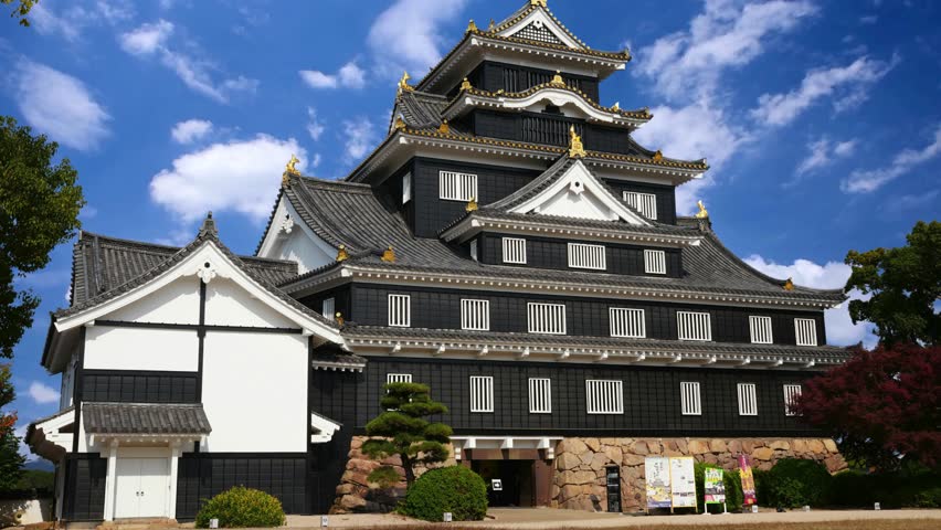 Nagoya Castle, A view of the main keep (Tenshu) and surrounding structures of Nagoya Castle, a historic landmark in Japan, with visitors walking on the grounds.