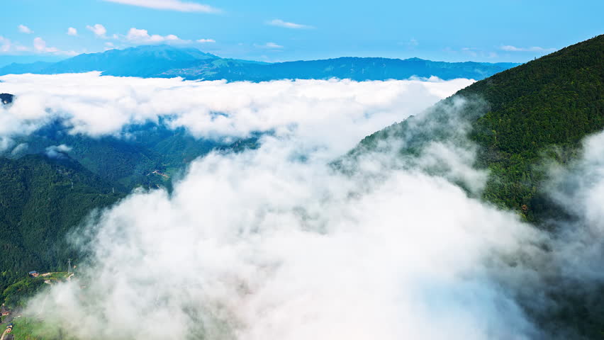 Dramatic sea of clouds covering the mountain valley under a blue sky in Guilin, China