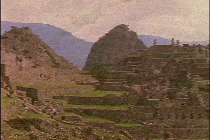 MS the ruins of Machu Picchu in Peru, camera keeps pulling back to show WS of ruins and mountain peaks.