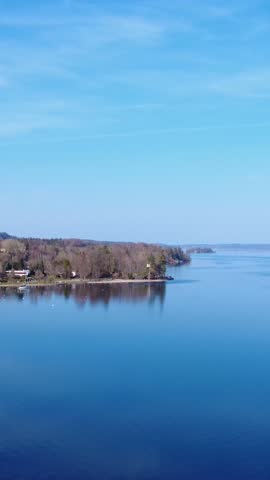 Beautiful Lake View With Trees and Clouds on a Clear Day Near a Calm Shore