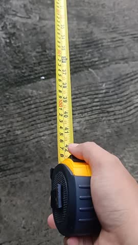 Close-up of a yellow measuring tape retracting back into its case, 10cm and 100cm length demonstration