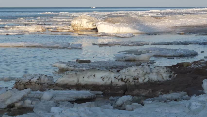 Close-up of Early Spring Thaw with Melting Ice on River Rocks