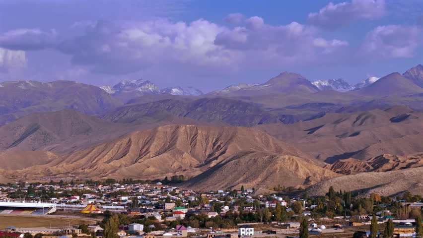 Mountain Town with Dry Hills and Snow Peaks Kyrgyzstan Aerial