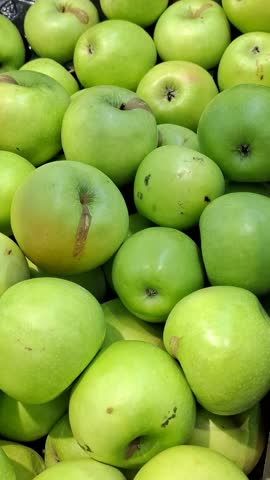 Ripe green apples at market. Close-up Granny Smith apples. Healthy lifestyle, organic farming, or grocery concepts. Crisp texture and vivid color of fruit. Natural snack for vegans and vegetarians