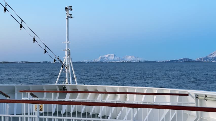 A ship navigates icy waters in Antarctica, with stunning views of snow-covered mountains and ice formations. The time is around noon, giving a clear look at the landscape.
