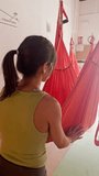 Yoga instructor guiding student in aerial hammock - Powered by Shutterstock - Get 15% off with code: PIKWIZARD15