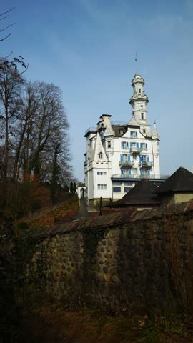 Vertical shot of the Chateau Guetsch hotel and its white castle-like architecture overlooking the city of Lucerne.