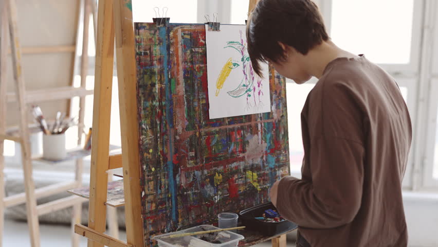Artist drawing with crayons in her art studio
