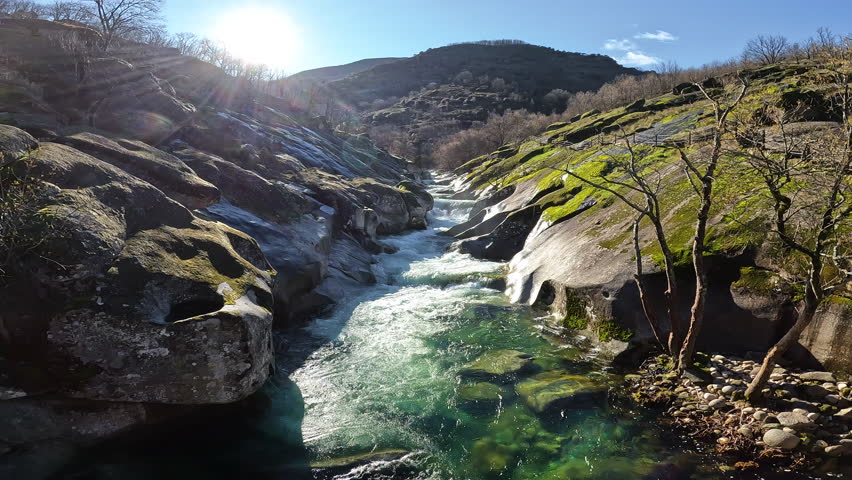 View of Los Pilones in Garganta de los Infiernos, Spain. Exceptional river flow surging through granite formations in Jerte Valley, creating powerful whitewater and dramatic flood-like natural landscape.