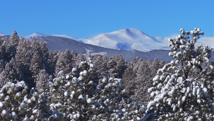 Winter morning Mt Blue Sky Mount Evans Front Range Rocky Mountains deep fresh snow sunny blue sky aerial drone Colorado Denver Evergreen Conifer prominent snow capped peak snowy forest trees circle