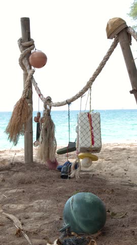 Static medium shot of rustic fishing equipment and styrofoam floats on a tropical beach