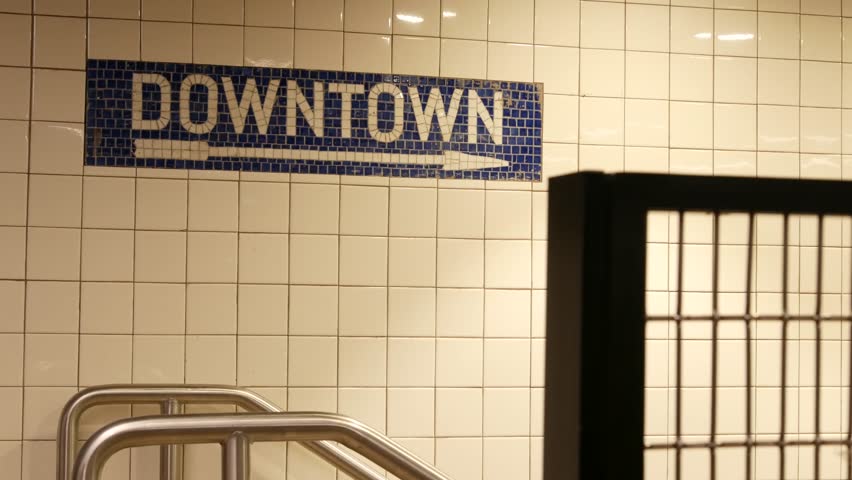 New York City Manhattan Midtown underground subway, Downtown metro direction, United States railway. Public metropolitan transport in USA, american railroad navigation. Sign on wall, tiles and arrow.
