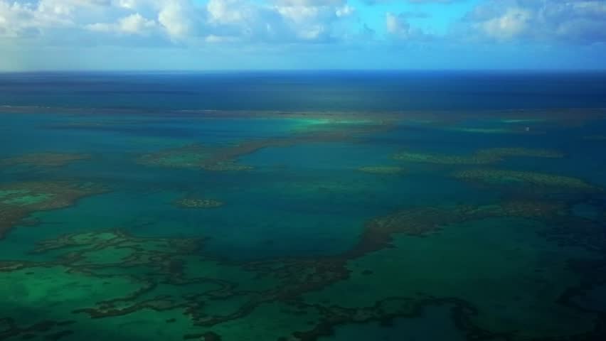 Great Barrier Reef scenic flight aerial drone Whitsundays Islands Australia QLD National Park Heart Reef Hardy Reef lagoon sunny serene coral formation clear Turquoise ocean waters blue sky clouds
