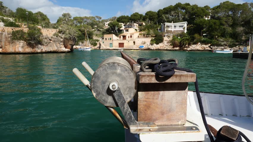 A fishing boat docked in the port of Cala Figuera. The cove in the background. Mallorca, Spain.