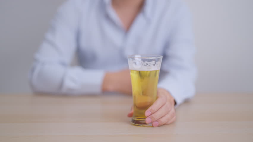 Stressed man drinking beer alone with problem. Exhausted drunk man looking stressed and sleepy. Alcohol addiction, Alcoholism, emotional distress and mental health concept 