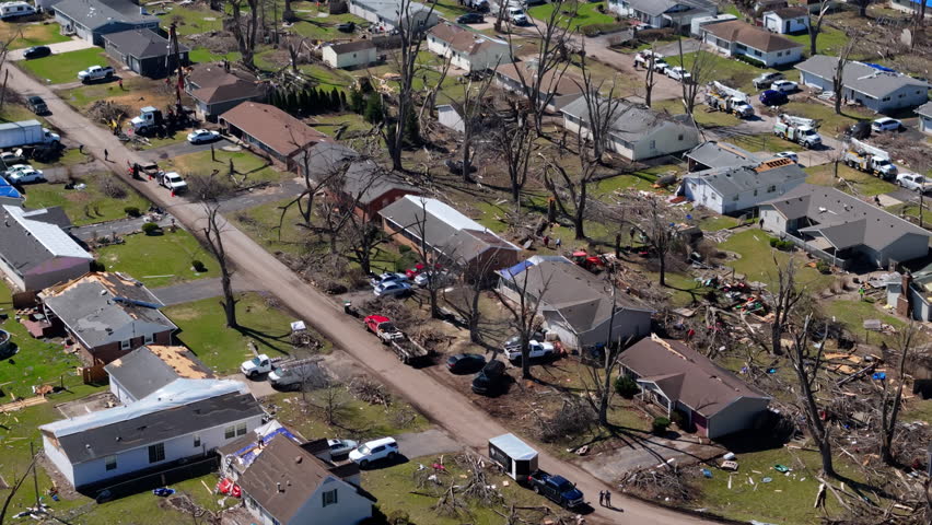 Aerial view of residential neighborhood destruction after a tornado with damaged houses and scattered debris.