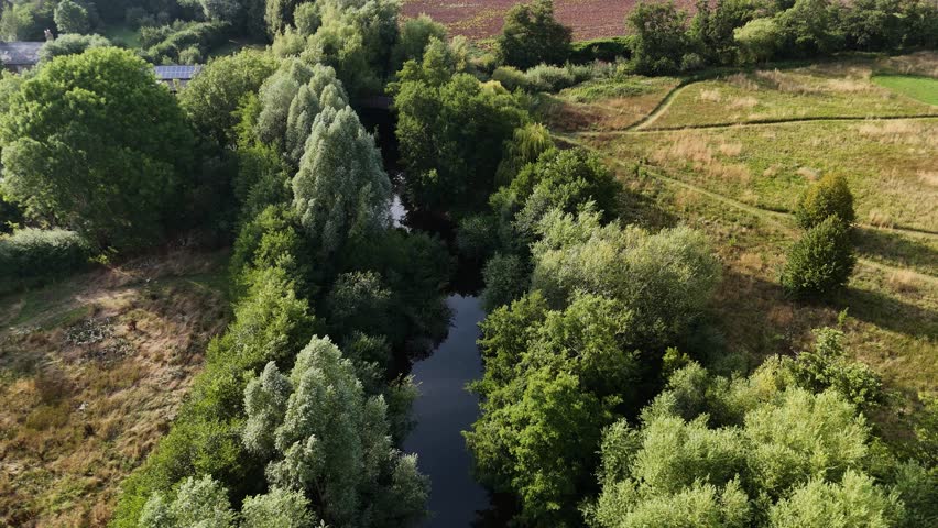 Skenfrith Herefordshire flight along the tree lined river showing cultivated fields on bright sunny Summer Day