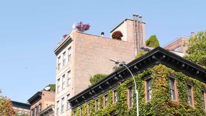 New York City urban residential buildings architecture, Lower Manhattan West village Greenwich street corner, United States of America. Greenwich village, USA. Red brick house. Vine greenery on wall.