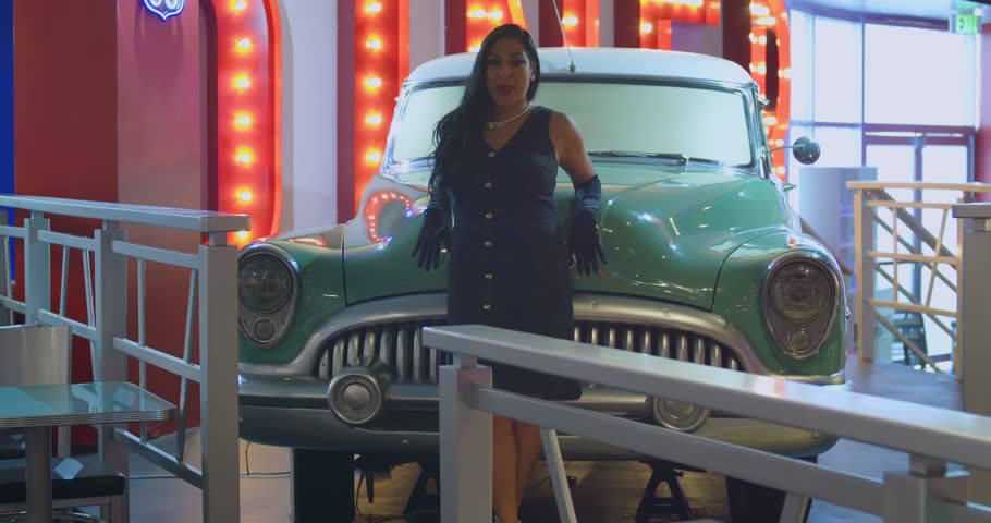A girl dancing and singing on a sun-drenched street in a vibrant tropical town.