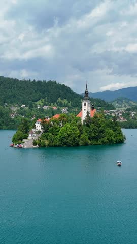 Bled Island with Church, Traditional Pletna Boats on Lake, Low Aerial Flight, Vertical