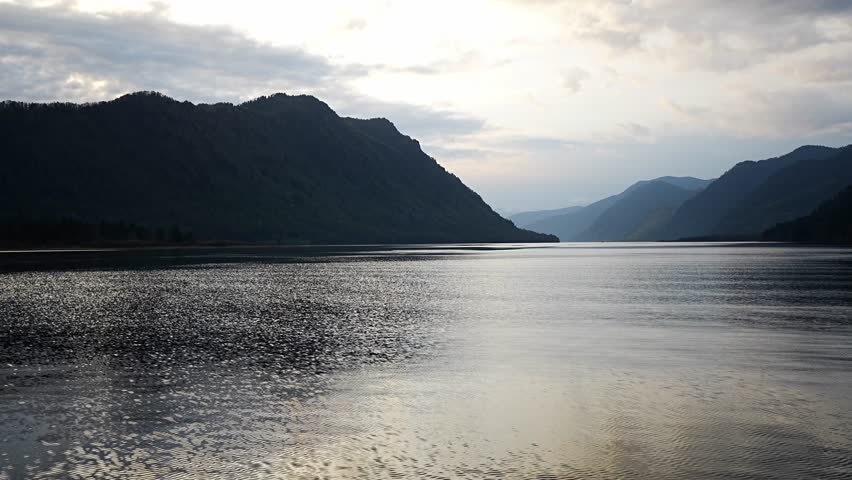 Early morning landscape of Teletskoye lake in Altai Russia. Calm water, soft light and serene mountain atmosphere near Artybash. High quality 4k footage