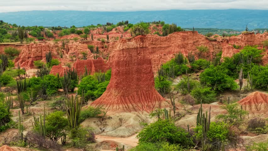 Cinematic backward drone footage flying over the stunning red rock formations of the tatacoa desert