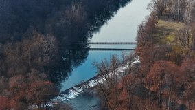 Aerial drone view of a footbridge crossing the Dyje River above a small weir in Podyjí National Park, Czech Republic. Calm river reflections and autumn forest landscape in Central Europe. - Powered by Shutterstock - Get 15% off with code: PIKWIZARD15